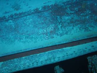 Large section of hull in debris field with "08KO" painted on plating